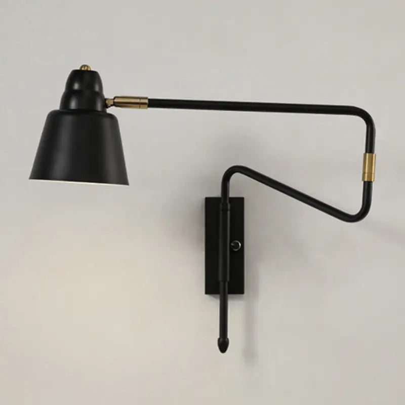 Modern black and brass wall-mounted reading lamp with a sleek retractable arm for bedroom lighting