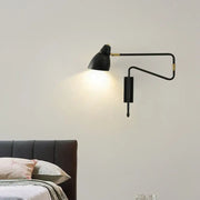 Modern black and brass wall light with articulated arms and backplate width designed for bedroom or studio use with e26 bulb base