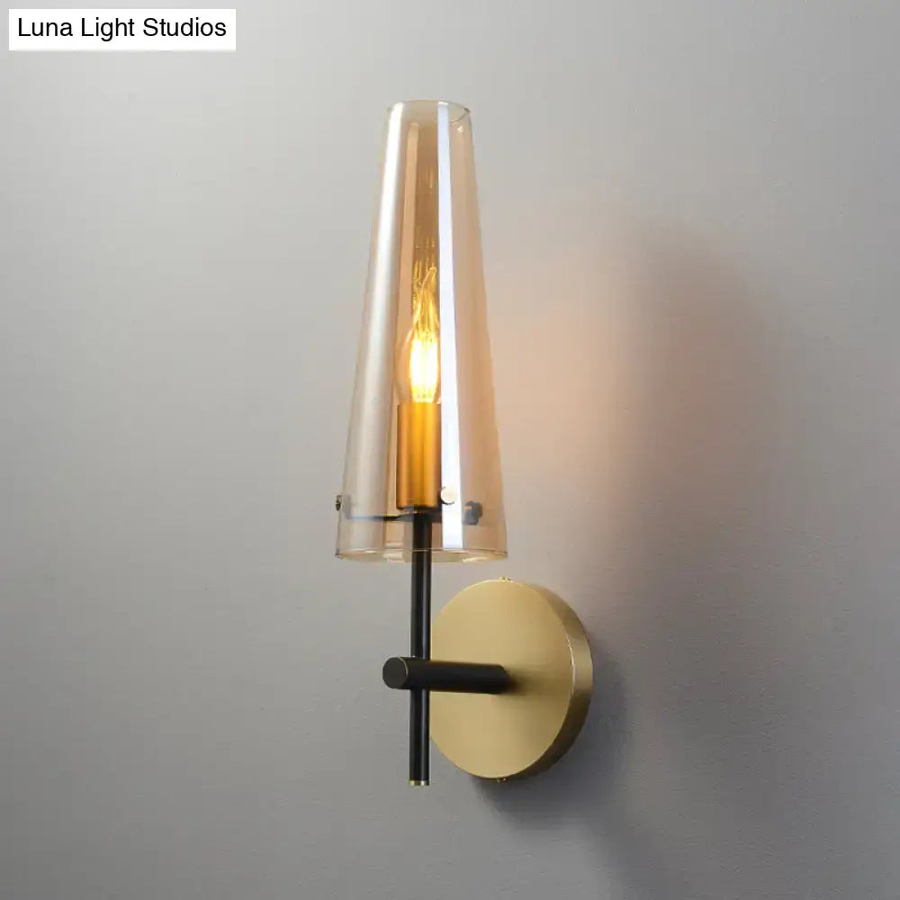 Modern black and brass wall mount light with warm amber glass shade and exposed filament bulb for study room wall light