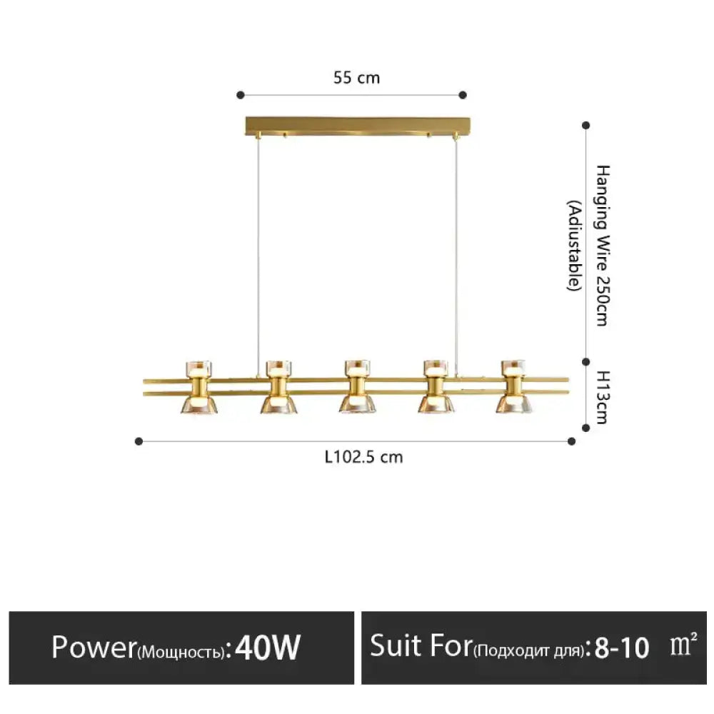 Modern black and chrome linear led strip lamp with gold-toned pendant light and faceted glass shades for kitchen island lighting