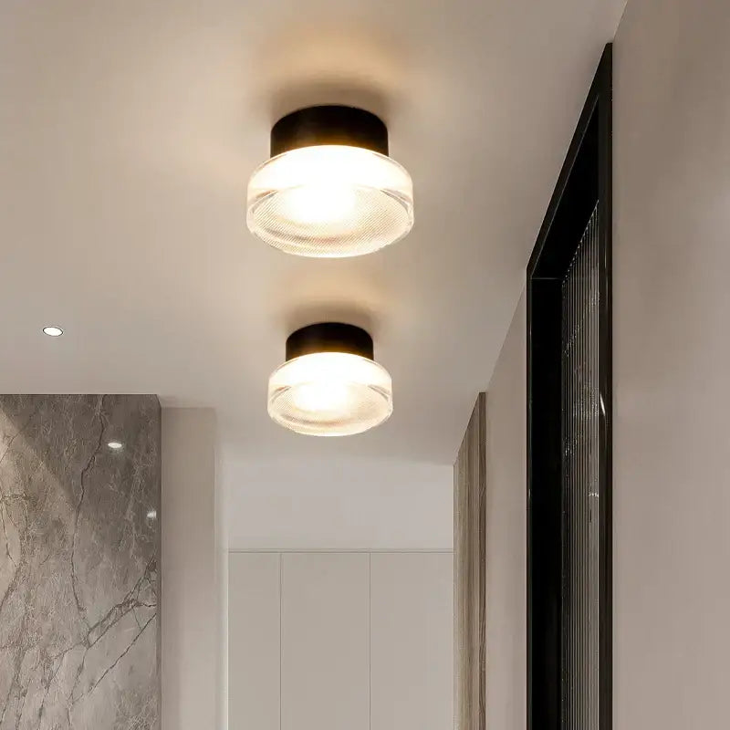 Modern black and clear acrylic wall sconce light with frosted glass diffuser emitting warm glow for bedroom lamp