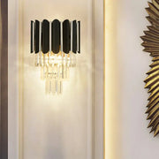 Modern black wall sconce with clear crystal vertical slats and dangling crystals for bedroom lighting