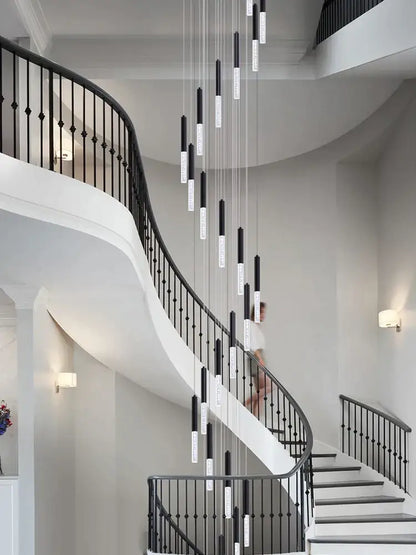 Modern black and clear glass decorbites cylindrical chandelier with black and white cylindrical pendant lights in staircase decor