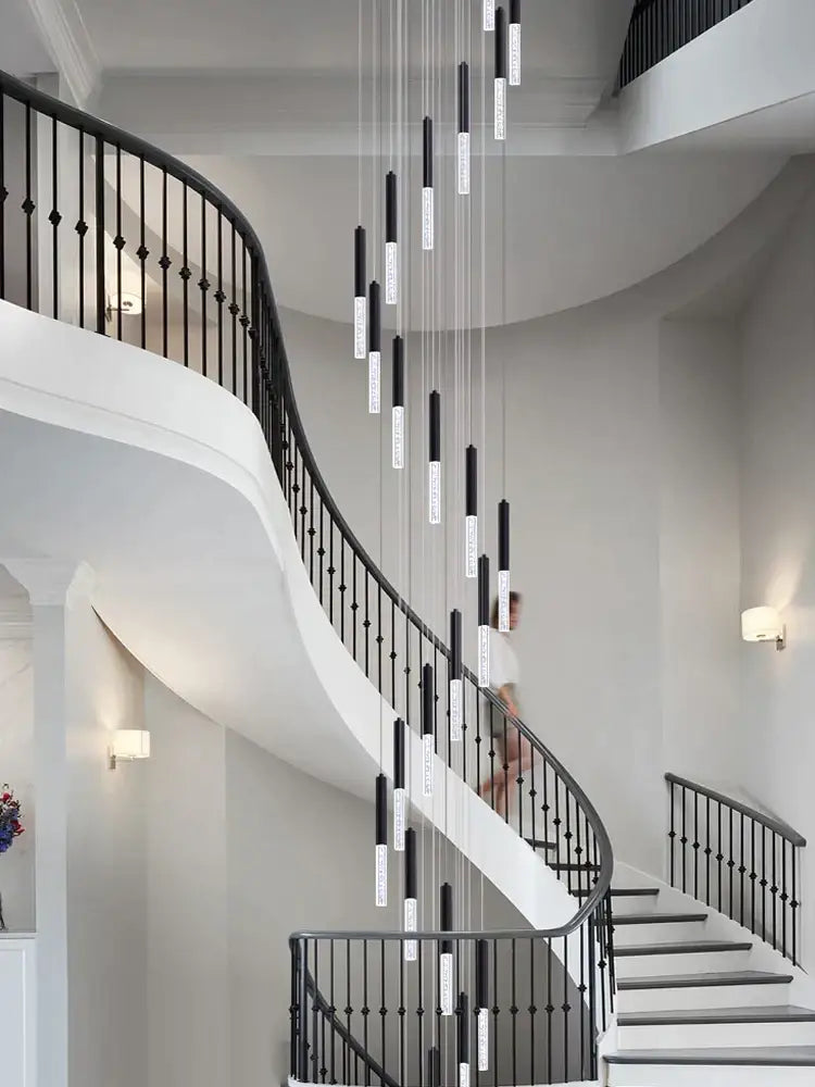 Modern black and clear glass decorbites cylindrical chandelier with black and white cylindrical pendant lights in staircase decor