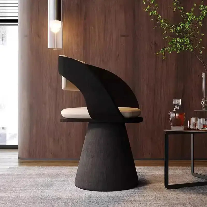 Black sculptural elegant rotating chair with cream cushion and tapered textured base for bedroom makeup stool