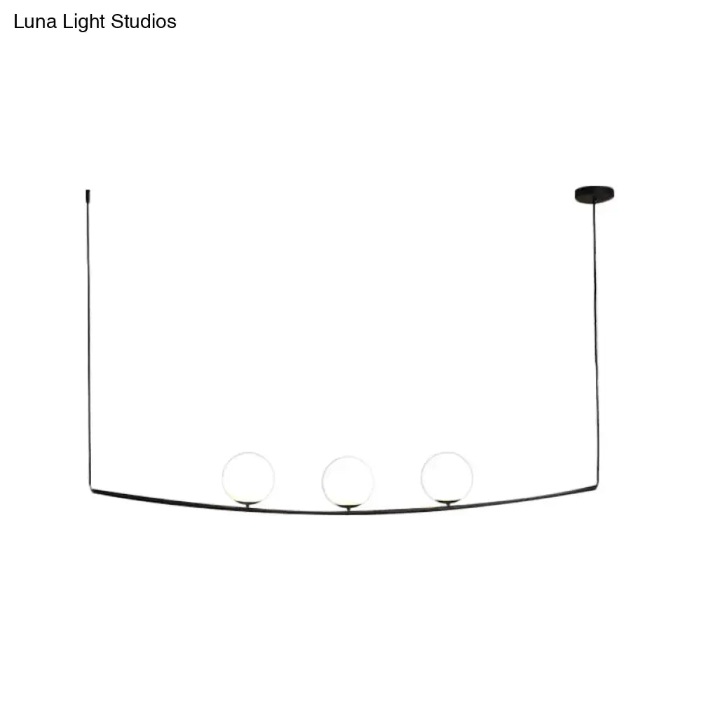 Black minimalist pendant light with three glass bulbs on a curved metal frame in black gold light bubble island style