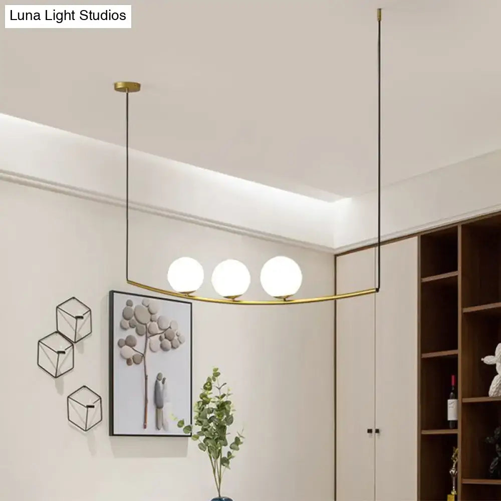 Modern metal chandelier with three frosted glass globes in black gold brass frame designed as light bubble island light