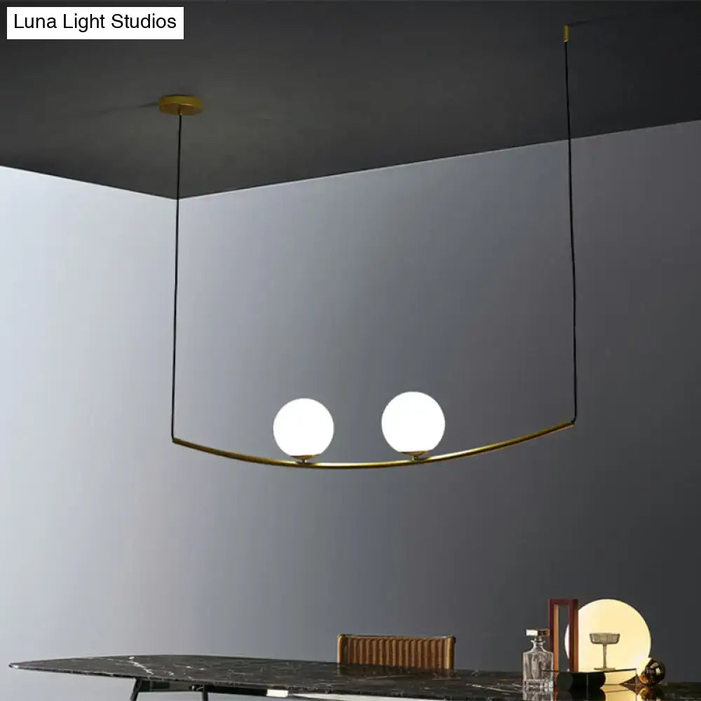 Modern brass pendant light with two white glass bulbs and black gold cords from decorbites bubble island light collection