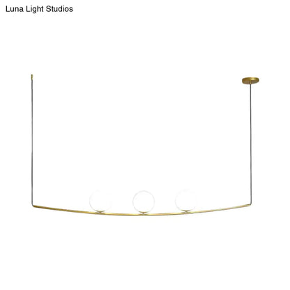 Gold-toned minimalist pendant light with three glass bulbs on a curved black gold metal frame for light bubble island use