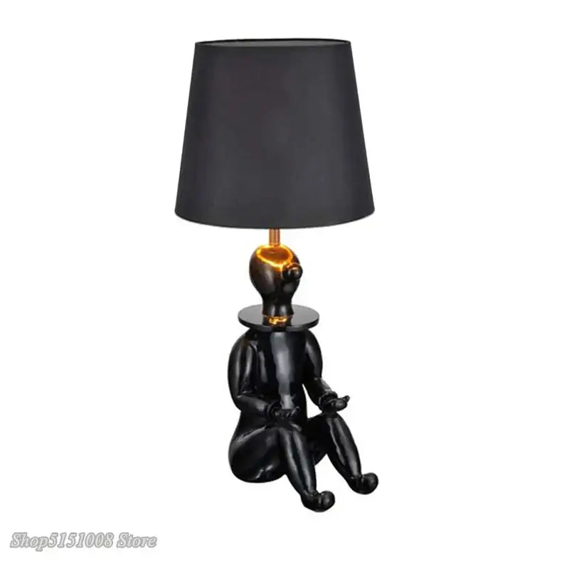 Modern black and gold ceramic decorbites clown desk lamp with glossy seated figure base and matte black conical shade