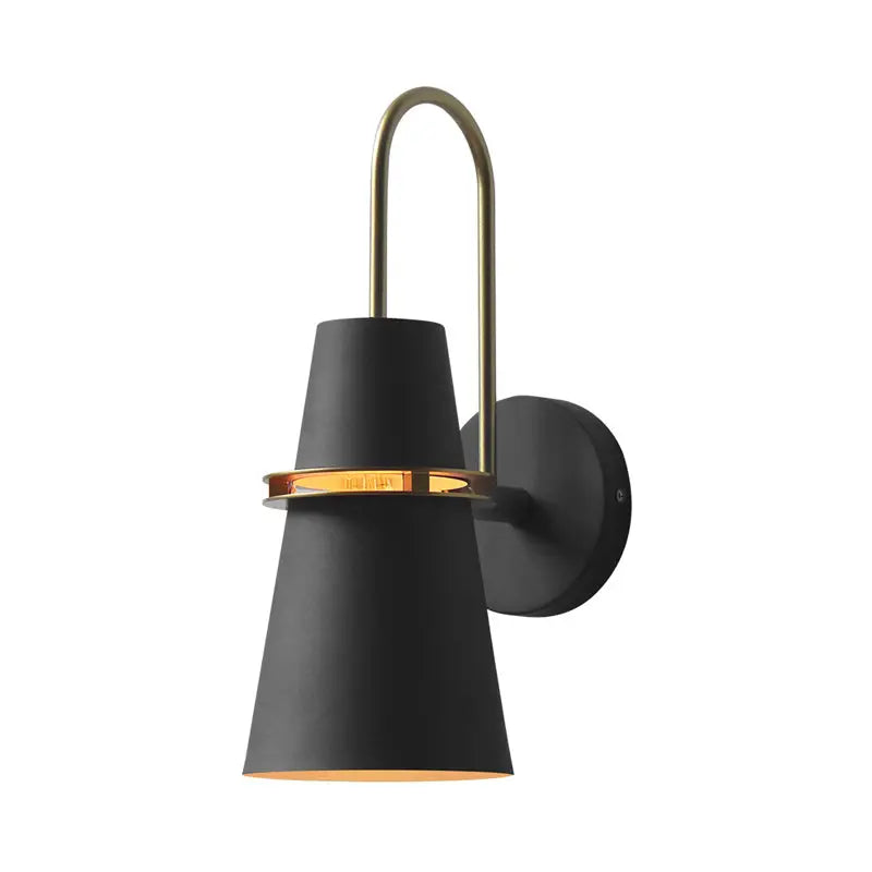 Modern black and gold conical wall sconce with brass accent ring and curved brass arm for dining room lighting