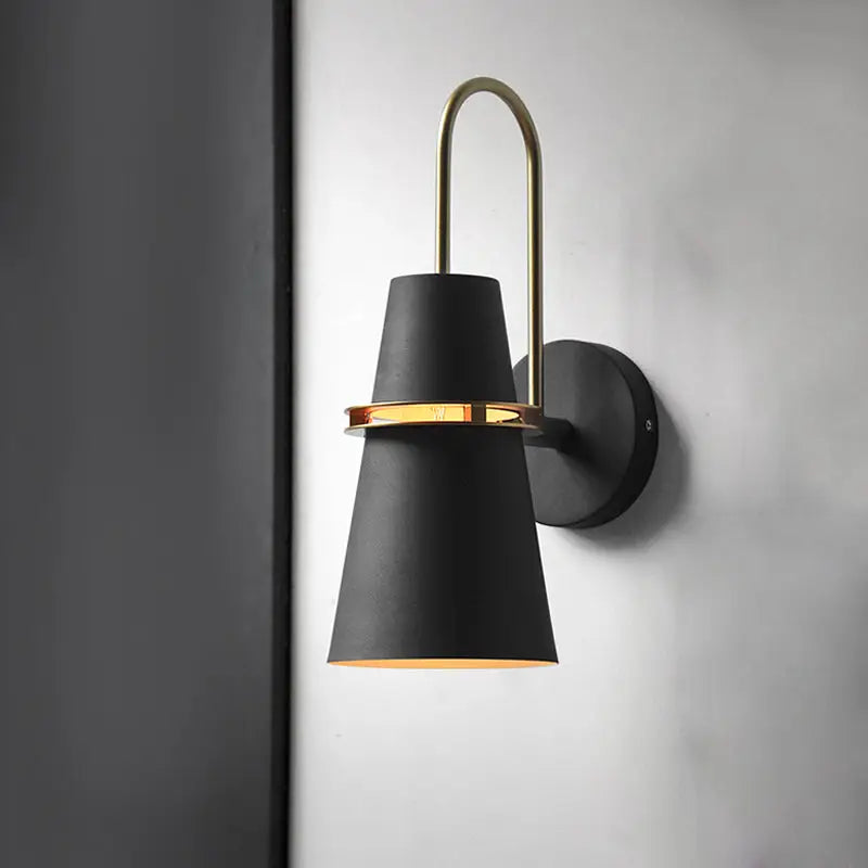 Modern black and gold conical sconce with black matte finish and brass accent ring for dining room wall lighting