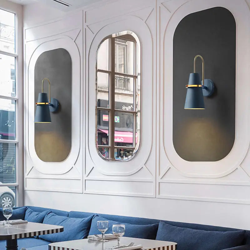 Modern black and gold conical wall sconce in navy blue with gold accents for dining room lighting