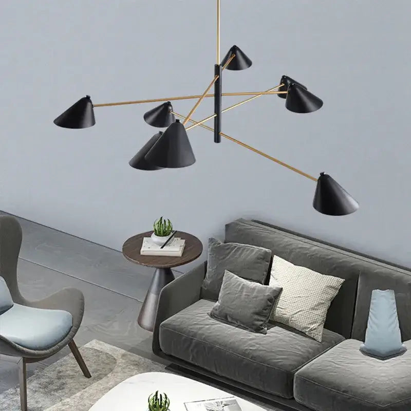 Modern black and gold decorbites cone shade chandelier with metal arms above gray velvet sofa for dining room