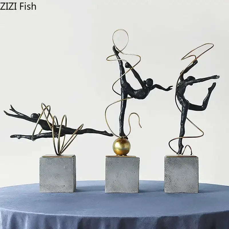 Set of three black metal decorbites gymnast figures with gold wire accents on gray concrete bases for living room decor