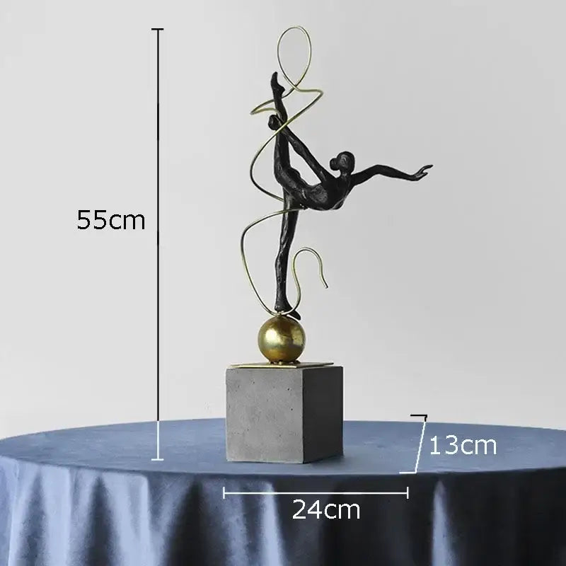 Modern black and gold decorbites gymnast figures statue featuring a ballerina mid-leap on a gold hoop and sphere base