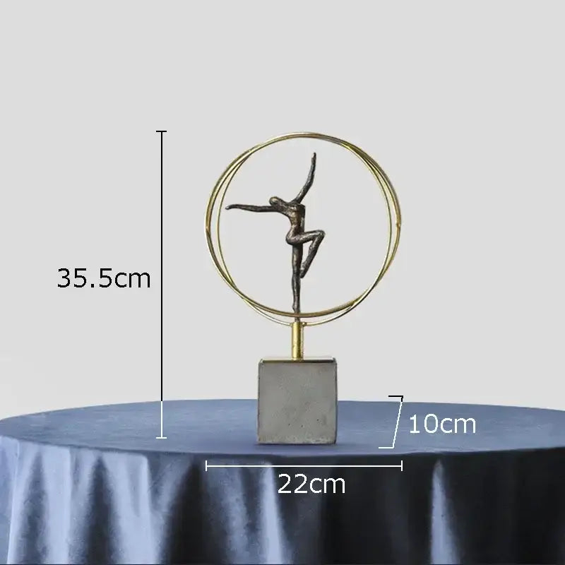A sleek metallic decorbites gymnast figures statue with gold rings on concrete base for living room decor