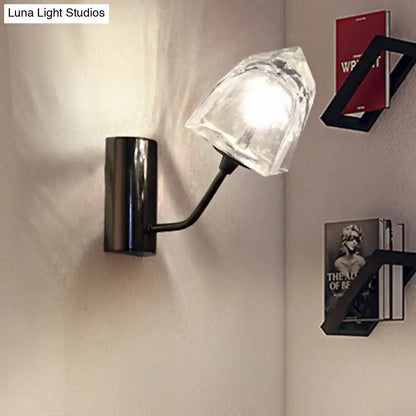 Modern black metal wall sconce with faceted clear glass shade featuring bulb base, fixture height, and backplate width details