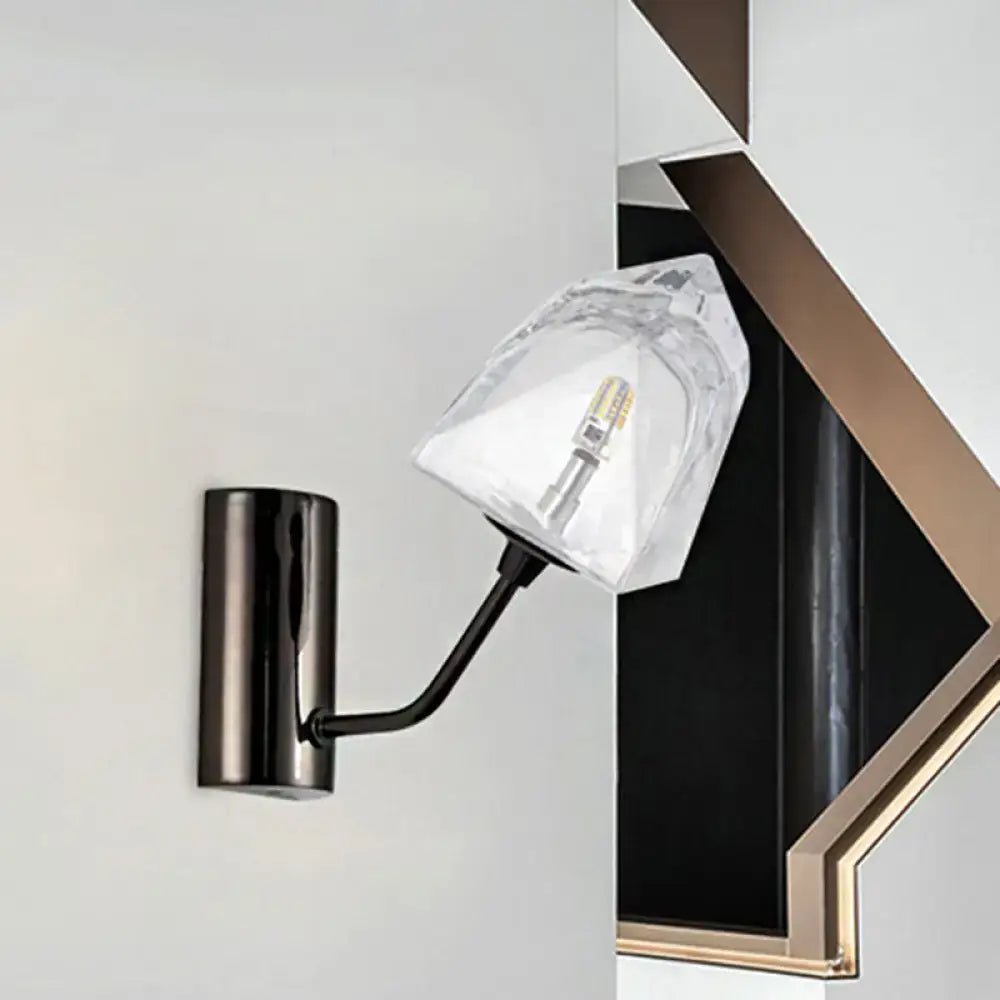 Modern black and gold wall sconce with faceted clear glass shade featuring bulb base and backplate width details