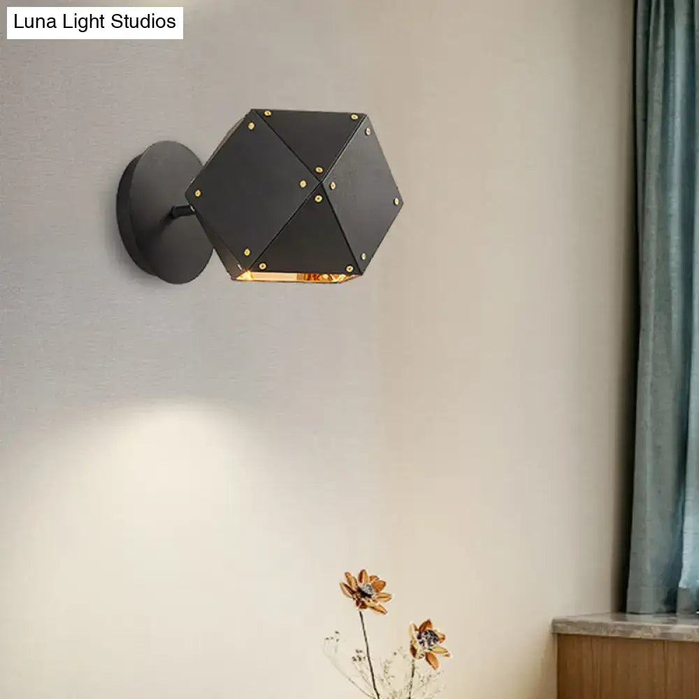 Modern black and gold geometric wall light with hexagonal shape and gold rivets providing warm dining room illumination