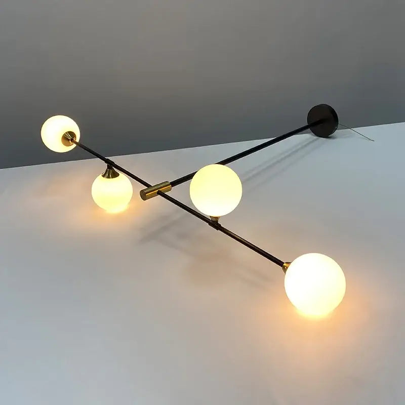 Modern black and gold glass ball pendant chandelier with four glowing frosted globe bulbs and brass accents decorbites glass ball