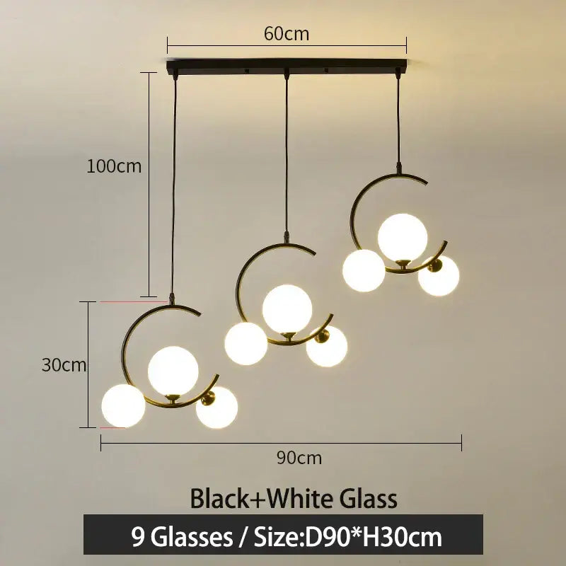 Modern black and gold glass ball pendant light with nine glowing white spheres in an asymmetrical design decorbites pendant light