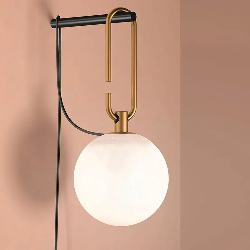 Modern black and gold glass ball pendant lights with a frosted globe, brass hook, and metal arm for dining room decorbites glass ball