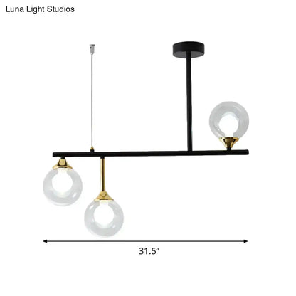 Modern black and gold pendant light fixture with three clear glass globe bulbs for dining room use