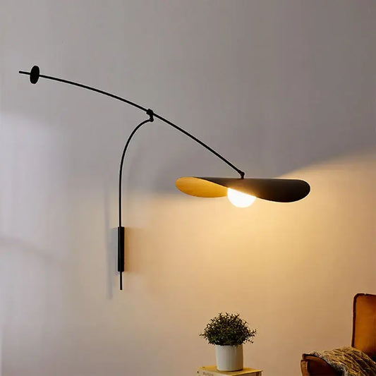 Modern black and gold leaf led wall lamp with glass shade and curved arm featuring warm golden interior for bedroom use
