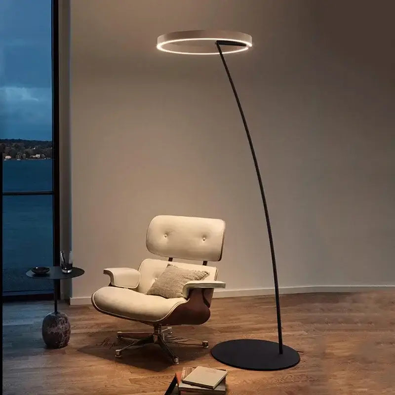 Modern black and gold led floor lamp with a sleek curved stand emitting warm ambient light for living room use
