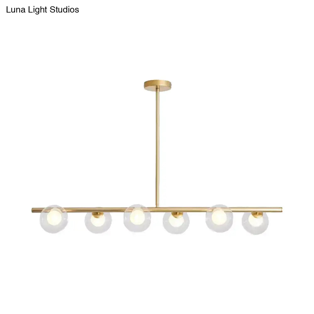 Gold-toned DecorBites™ pendant light with five frosted glass globe light bulbs for dining table use