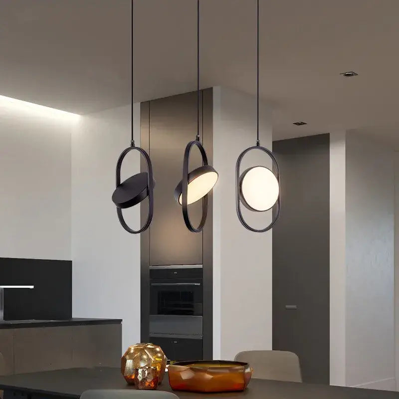 Three modern black pendant lights with circular frames complement decorbites gold trumpet pendant for dining room decor