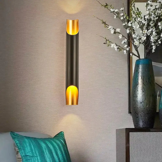 Modern black and gold tubular aluminum wall sconce with sleek cylindrical design for living room lighting