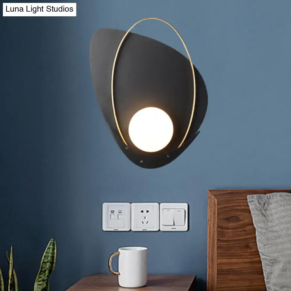 Modern black and gold wall lamp with a white glass shade and glowing round light fixture for bedroom sconce use
