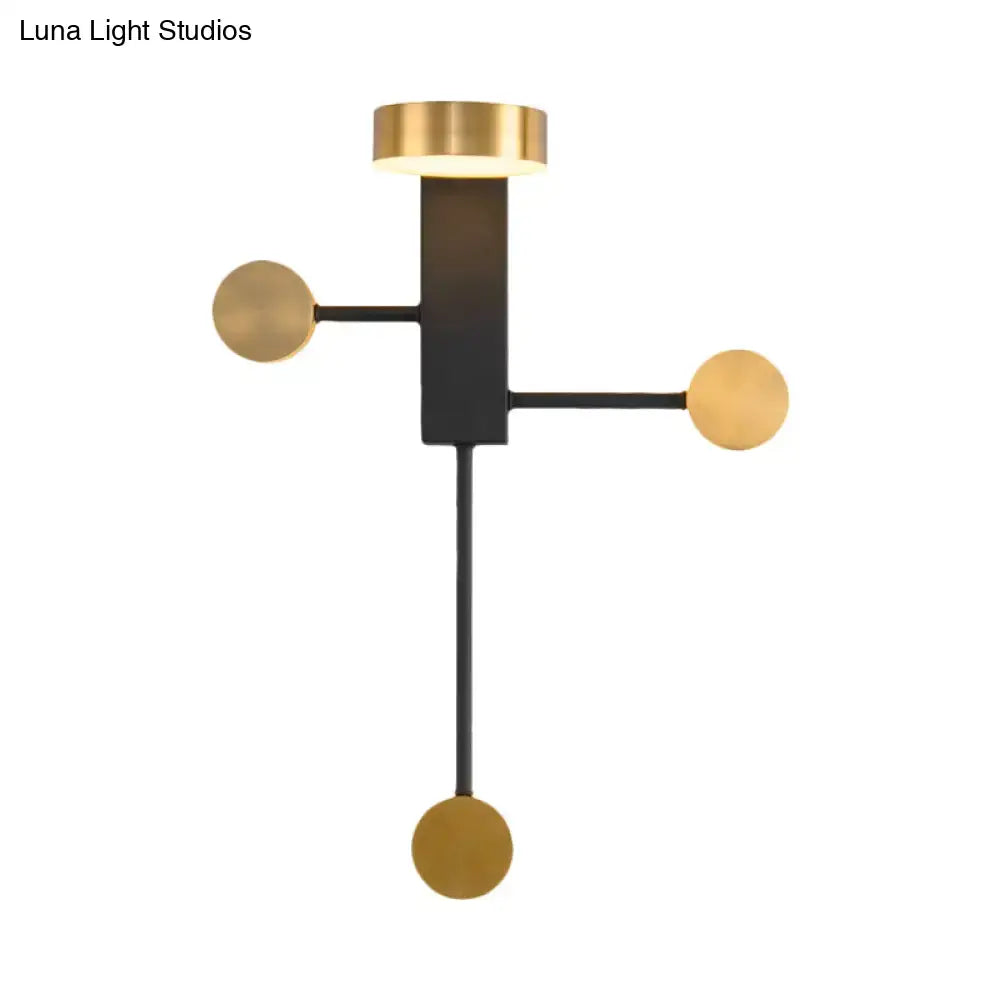 Modern black and gold wall sconce with a geometric design and brushed gold spherical accents for living room lighting