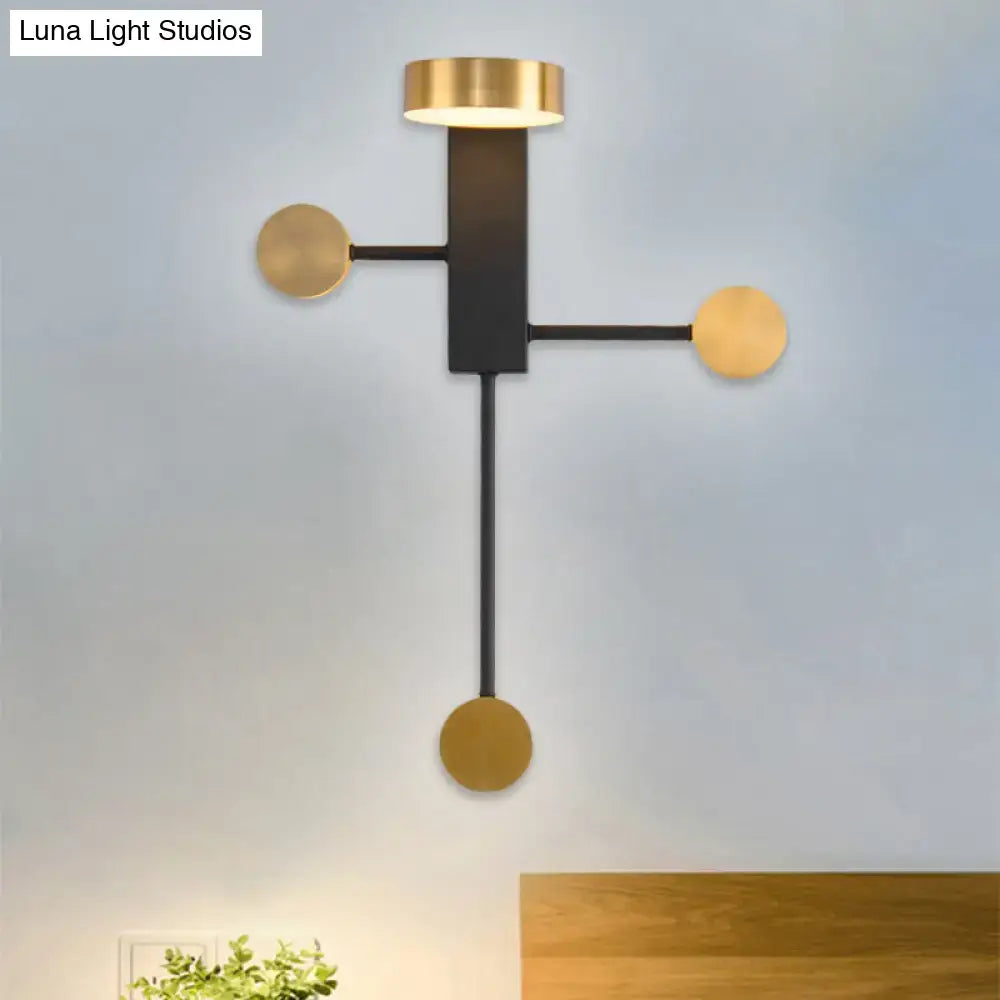 Modern black and gold wall sconce with a minimalist black frame and three gold circular accents with LED top light