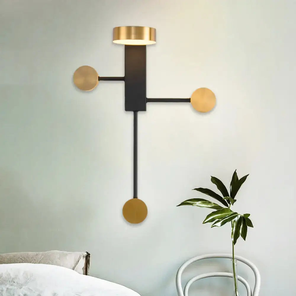 Modern black and gold wall sconce with rectangular body and three gold circular accents for living room LED light