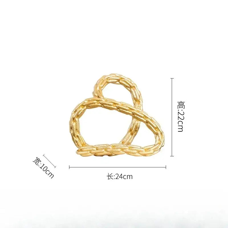 Modern black and golden knot chain sculpture with a gold-colored braided metal hair clip featuring a golden knot chain design