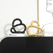 Modern black and golden knot chain sculpture decor featuring twisted golden knot chain design for living room display