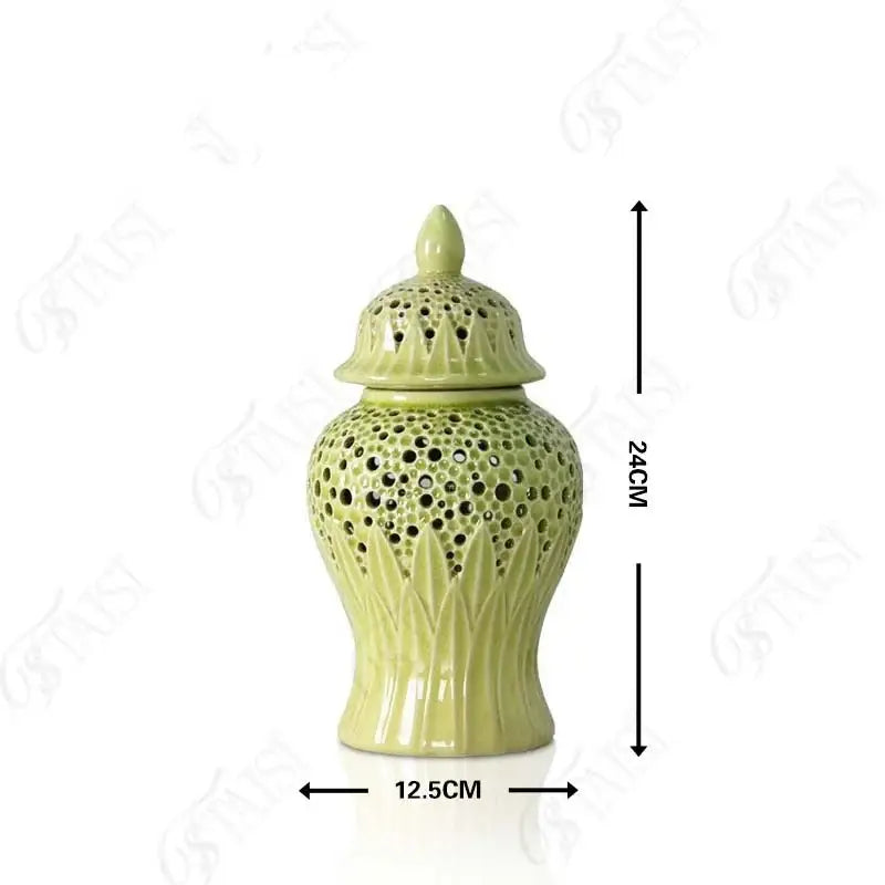 A light green porcelain jar with intricate perforated patterns and leaf embossing complementing golden porcelain décor