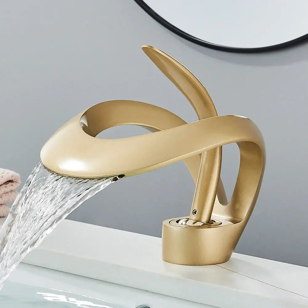 Gold-colored sleek waterfall mixer tap with modern sculptural form for bathroom basin faucet use