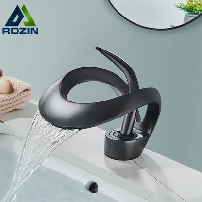 Modern black and grey waterfall mixer tap with matte finish and sleek sculptural design for bathroom basin faucet