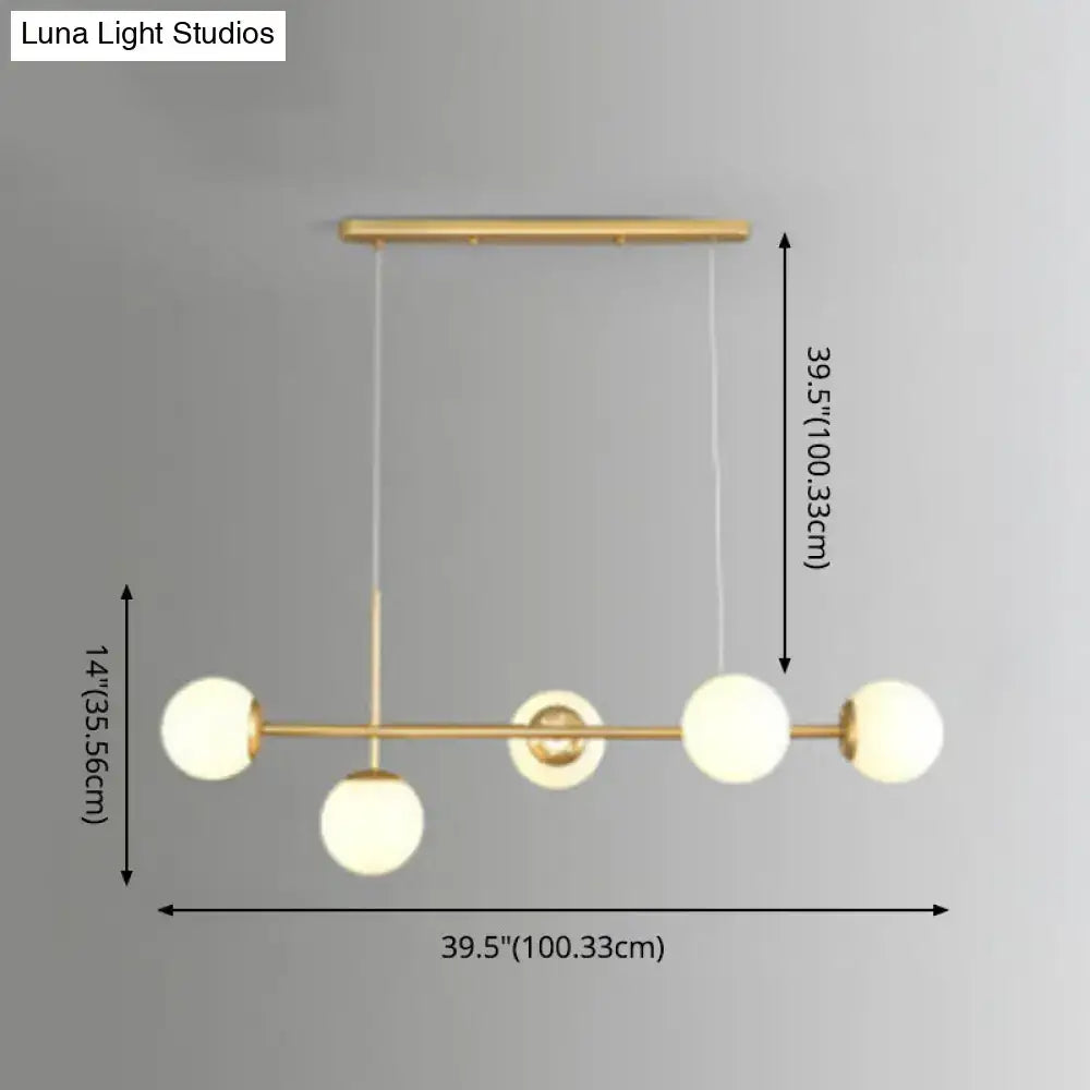 Modern black and white bird linear island pendant light with gold-toned frame and four frosted glass shade globes