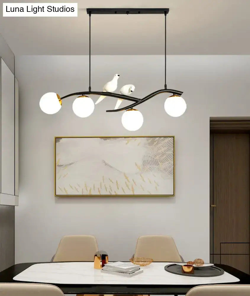 Modern black metal pendant light with three white glass shades and two white dove sculptures for linear island use