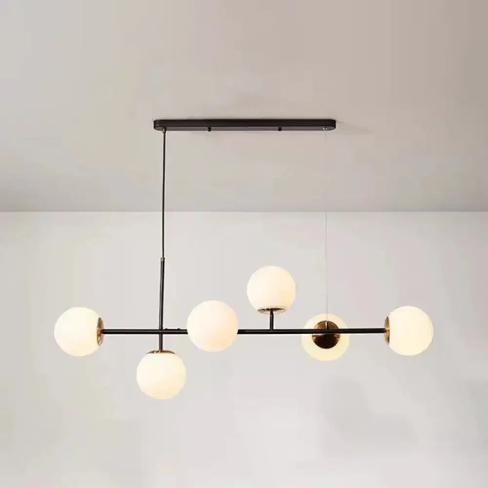 Modern black metal linear island pendant light with five frosted glass shade globes for dining room use