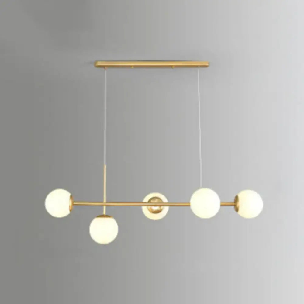 Modern black and white bird linear island pendant light with gold-toned frame and five frosted glass shade bulbs