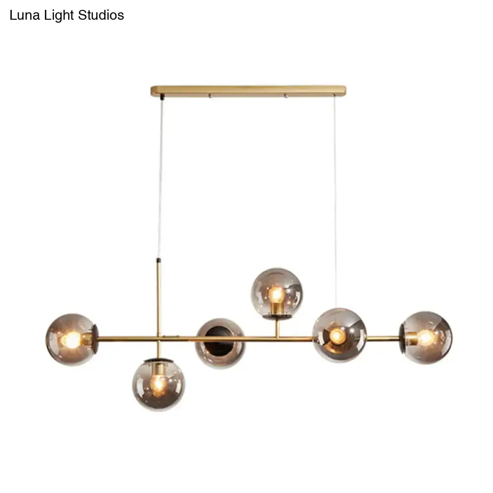 Modern brass pendant light with five smoked glass shade globe bulbs for black and white linear island dining room