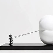 Modern black and white cartoon balloon man sculpture featuring a child figurine pulling a spherical balloon for decor