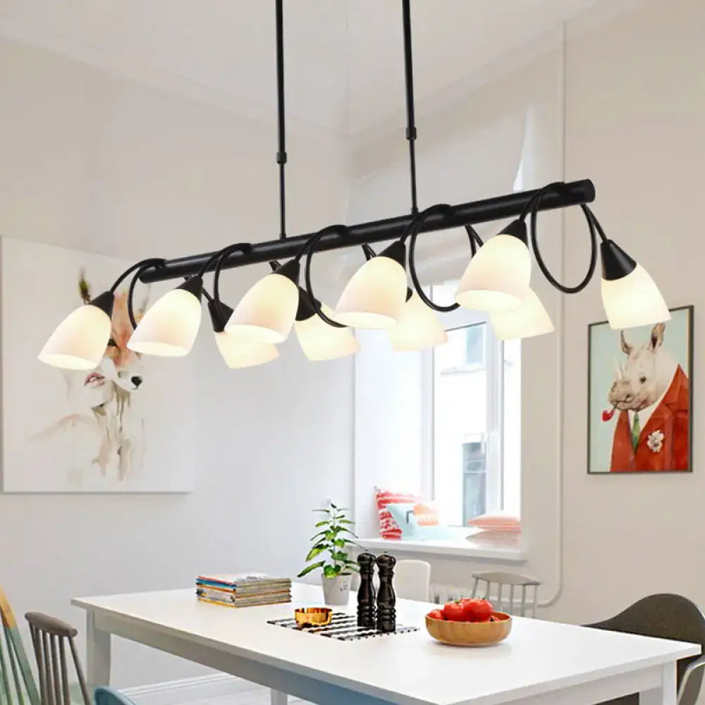 Modern black metal light fixture with multiple off-white glass shades for use as a kitchen pendant light
