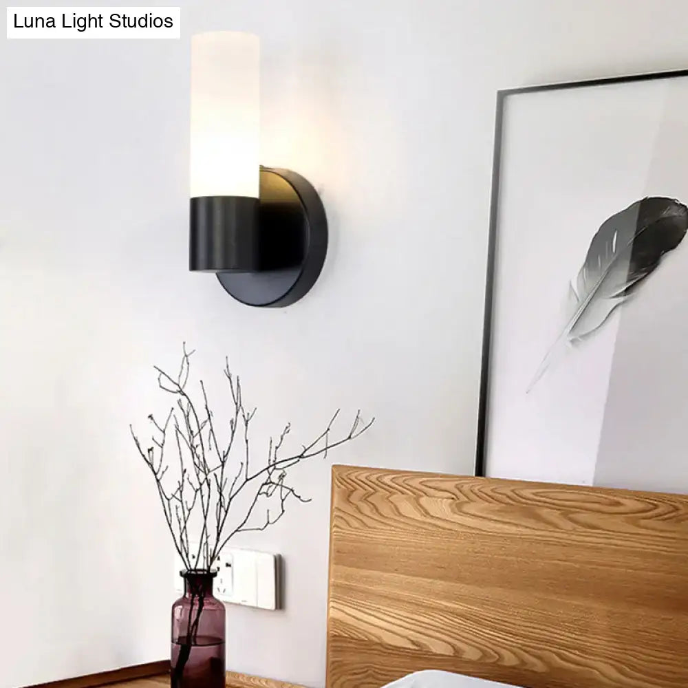 Modern black and white glass sconce lamp featuring a cylinder white glass shade for bedroom wall lighting